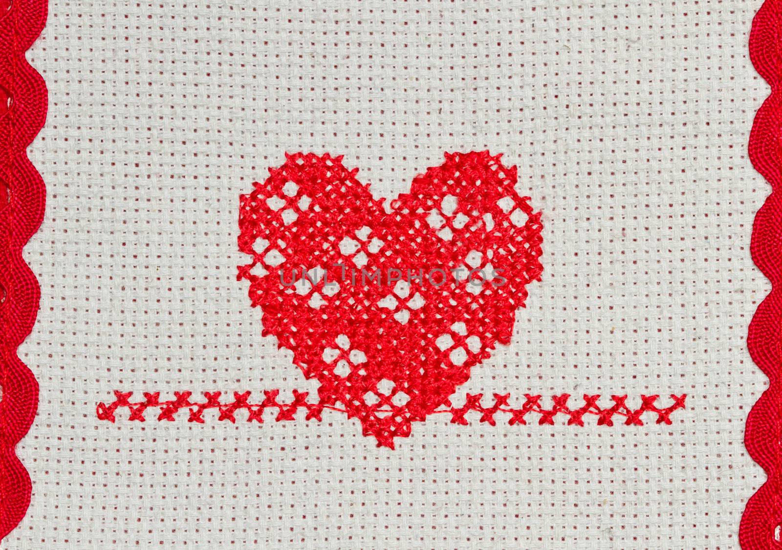 red heart embroidered in cross stitch on  canvas 