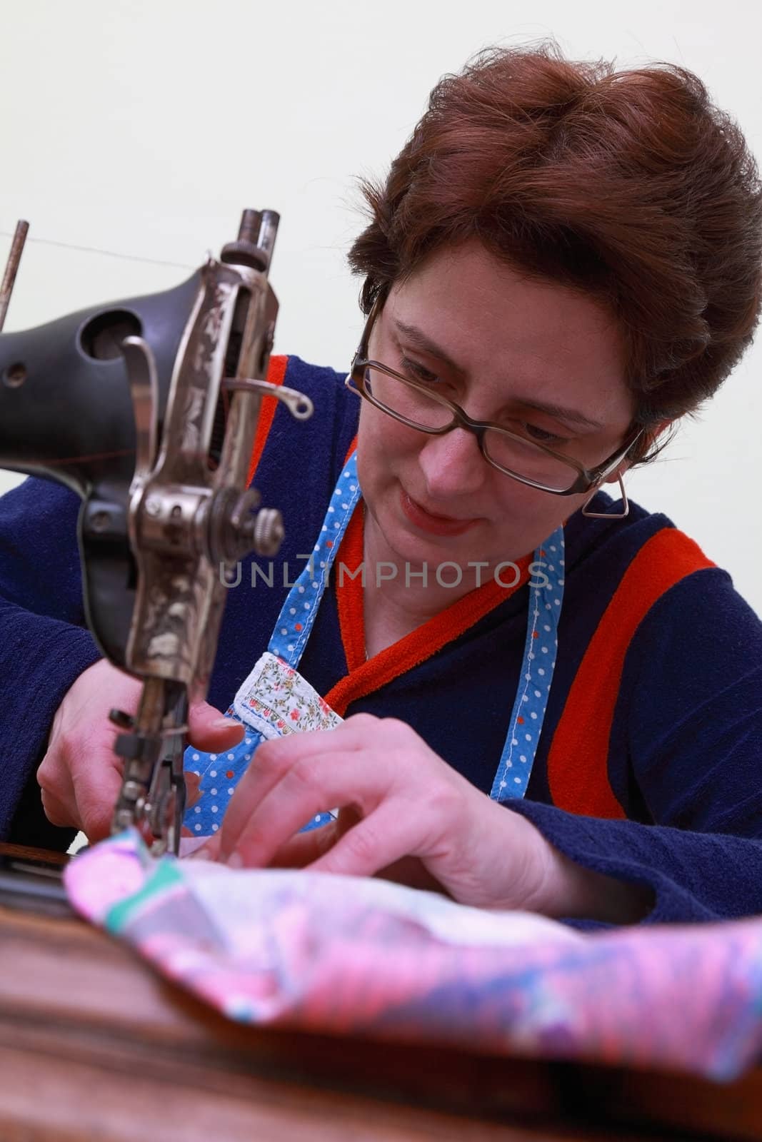 Close-up of a seamstress working with an old sewing machine.