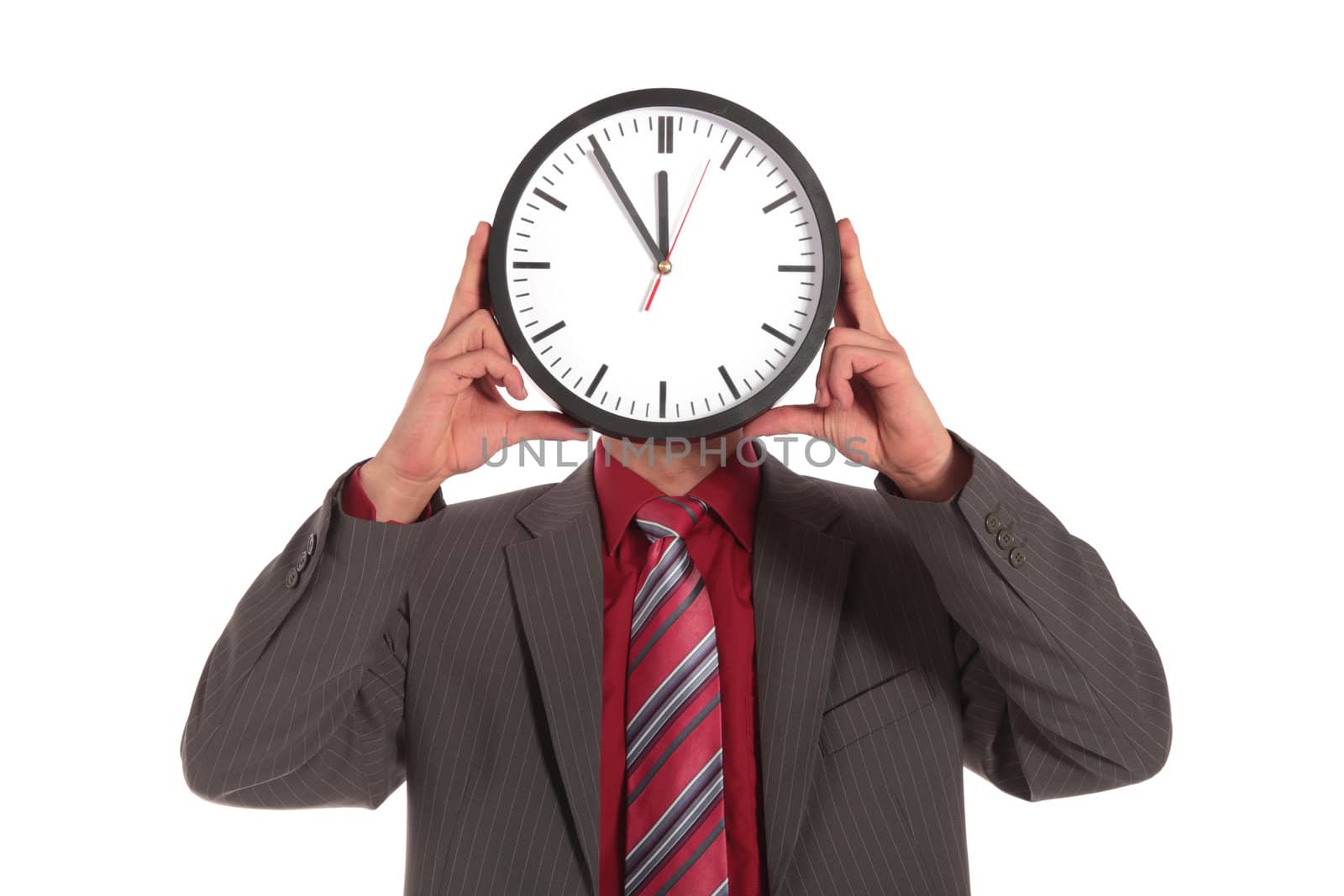 A businessman holding a clock that shows the eleventh hour right in front of his face. All on white background.