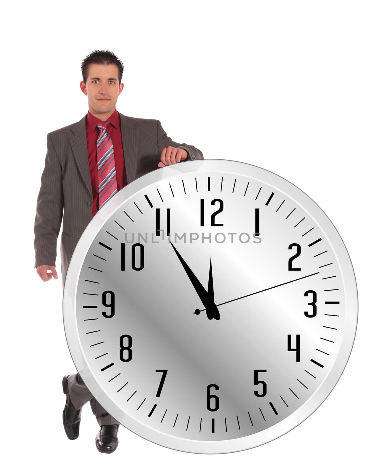 A handsome businessman standing next to a huge clock that shows the eleventh hour. All on white background.