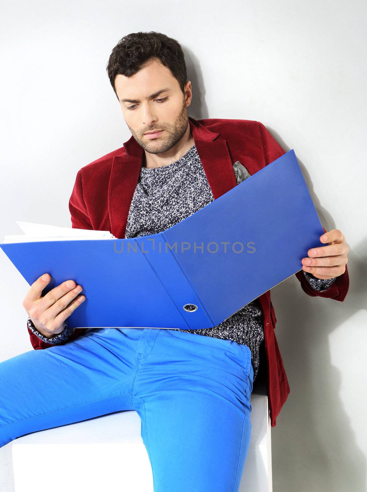 Portrait of businessman with a blue folder of documents by robert_przybysz