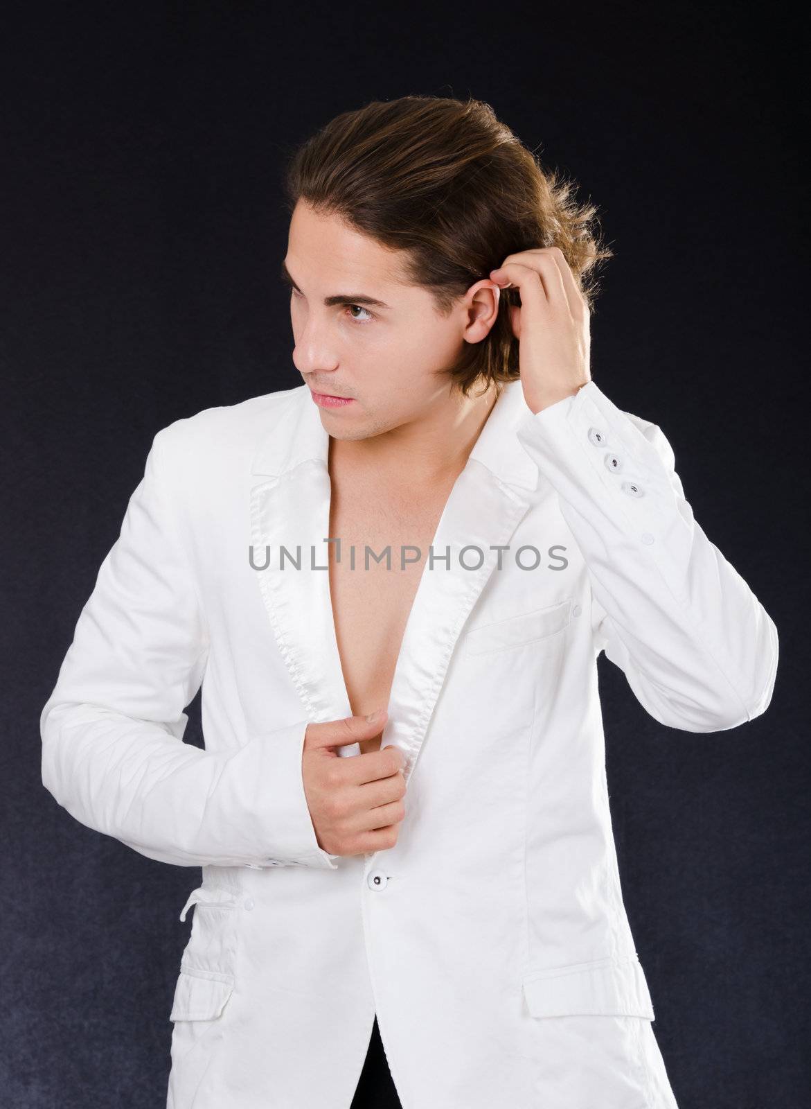 Young handsome man in the white jacket on black background