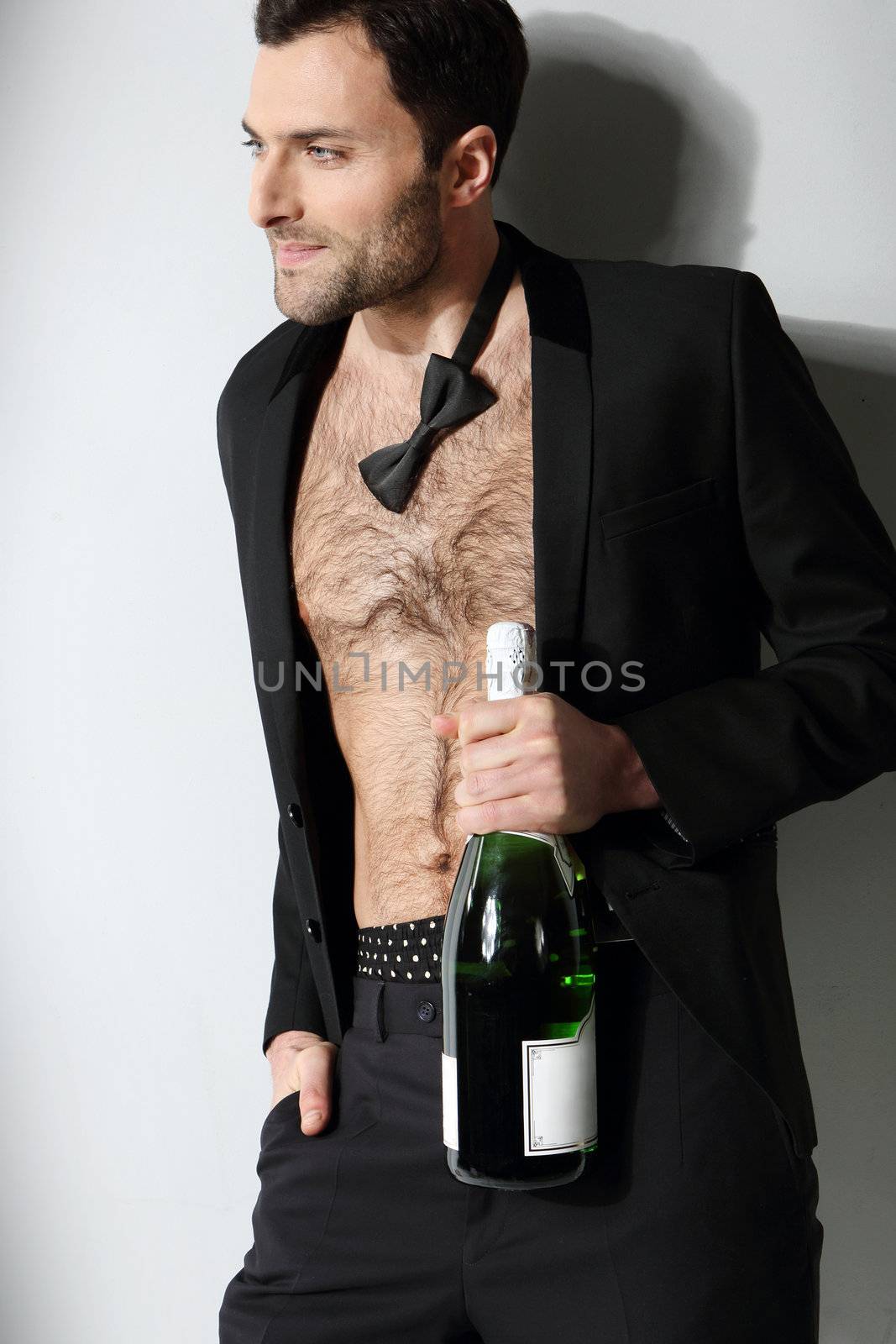 Sexy male model holding champagne bottle