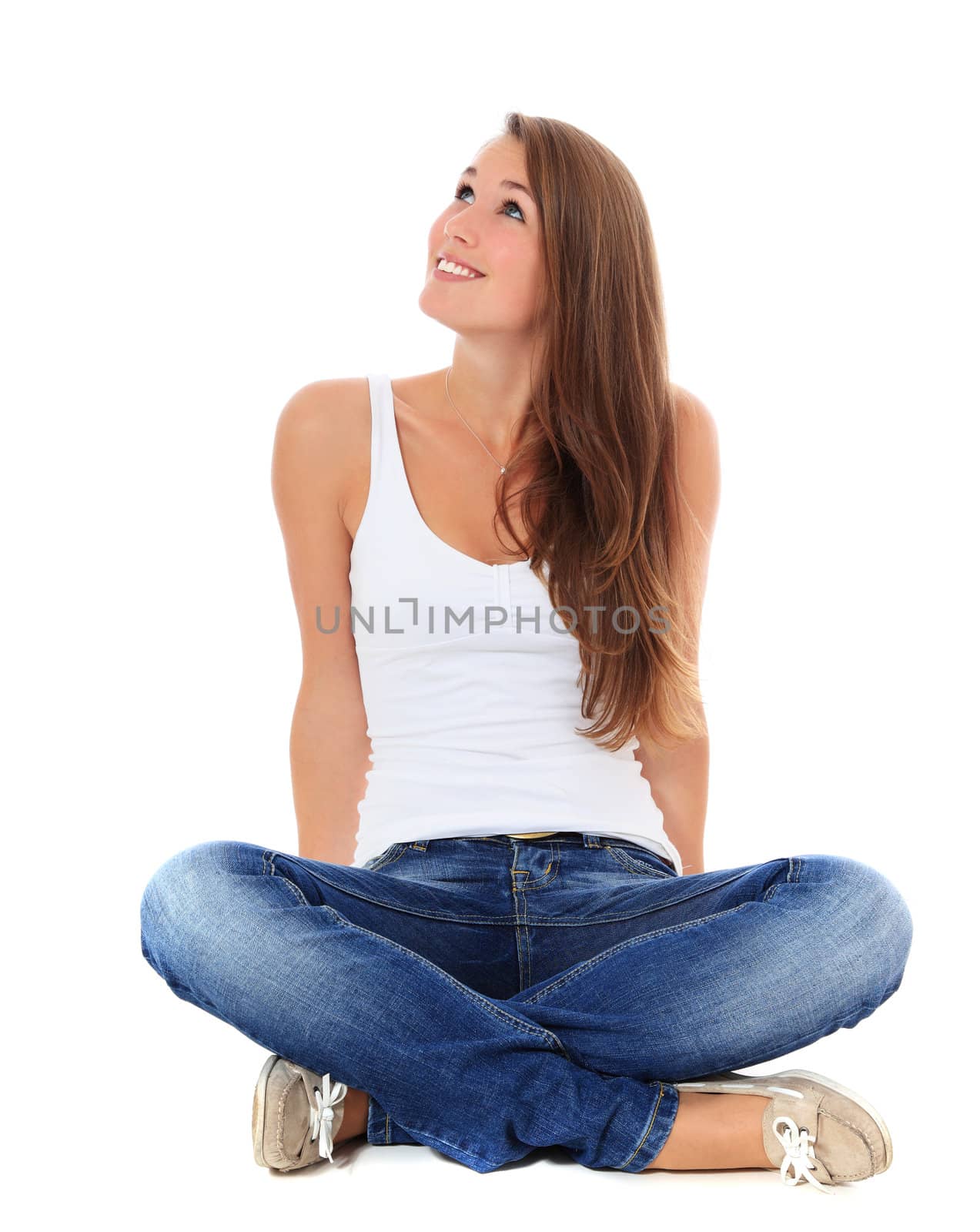 Attractive young woman sitting on the floor, looking up. All on white background.