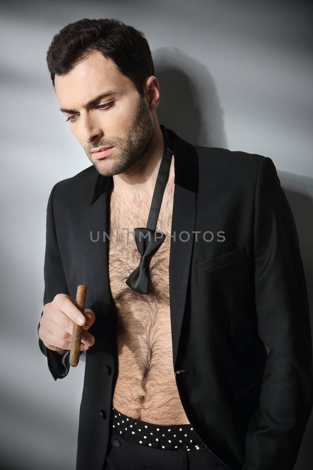 Sexy male model smoking cigar in open formal attire by robert_przybysz