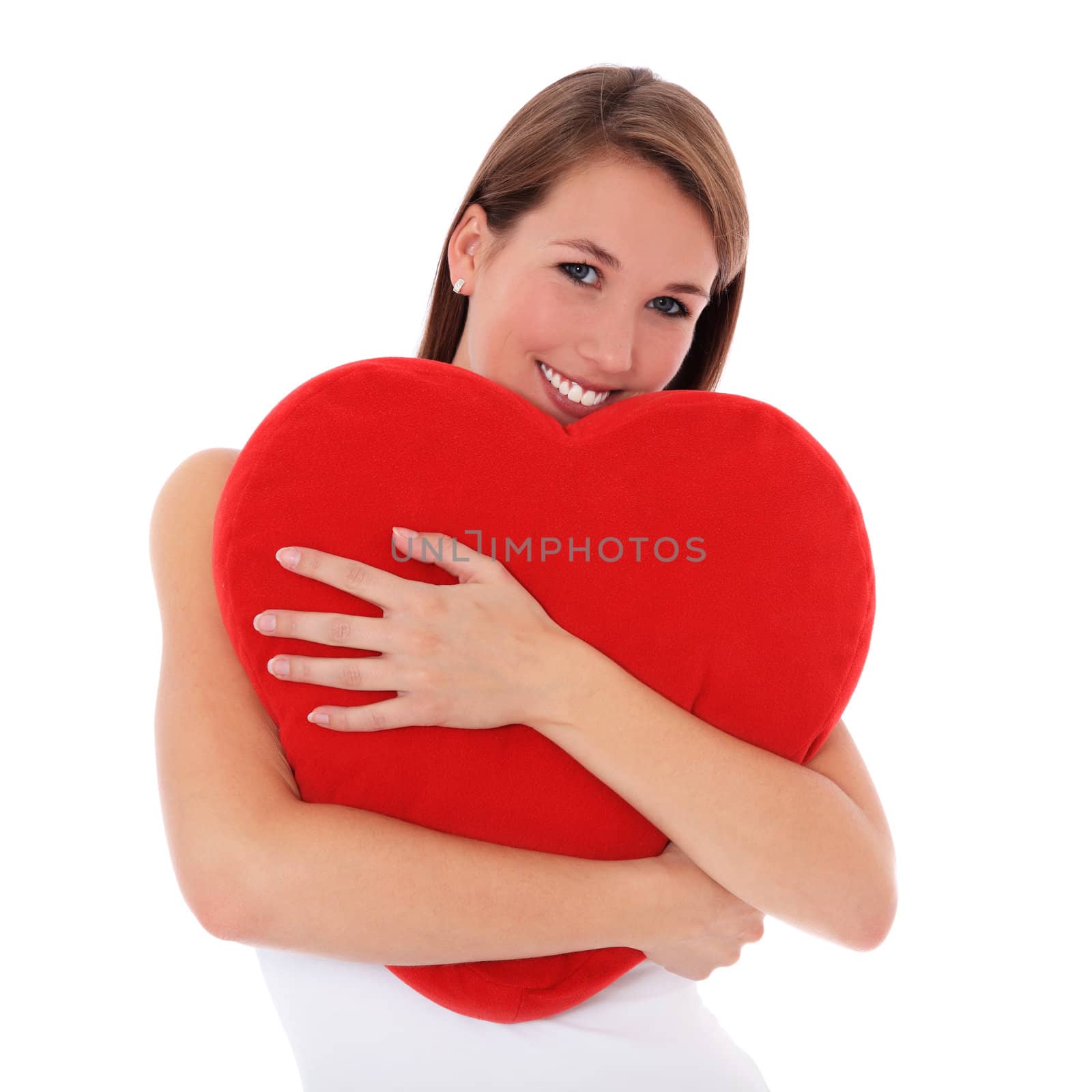Attractive young woman hugs red heart-shaped pillow. All on white background.