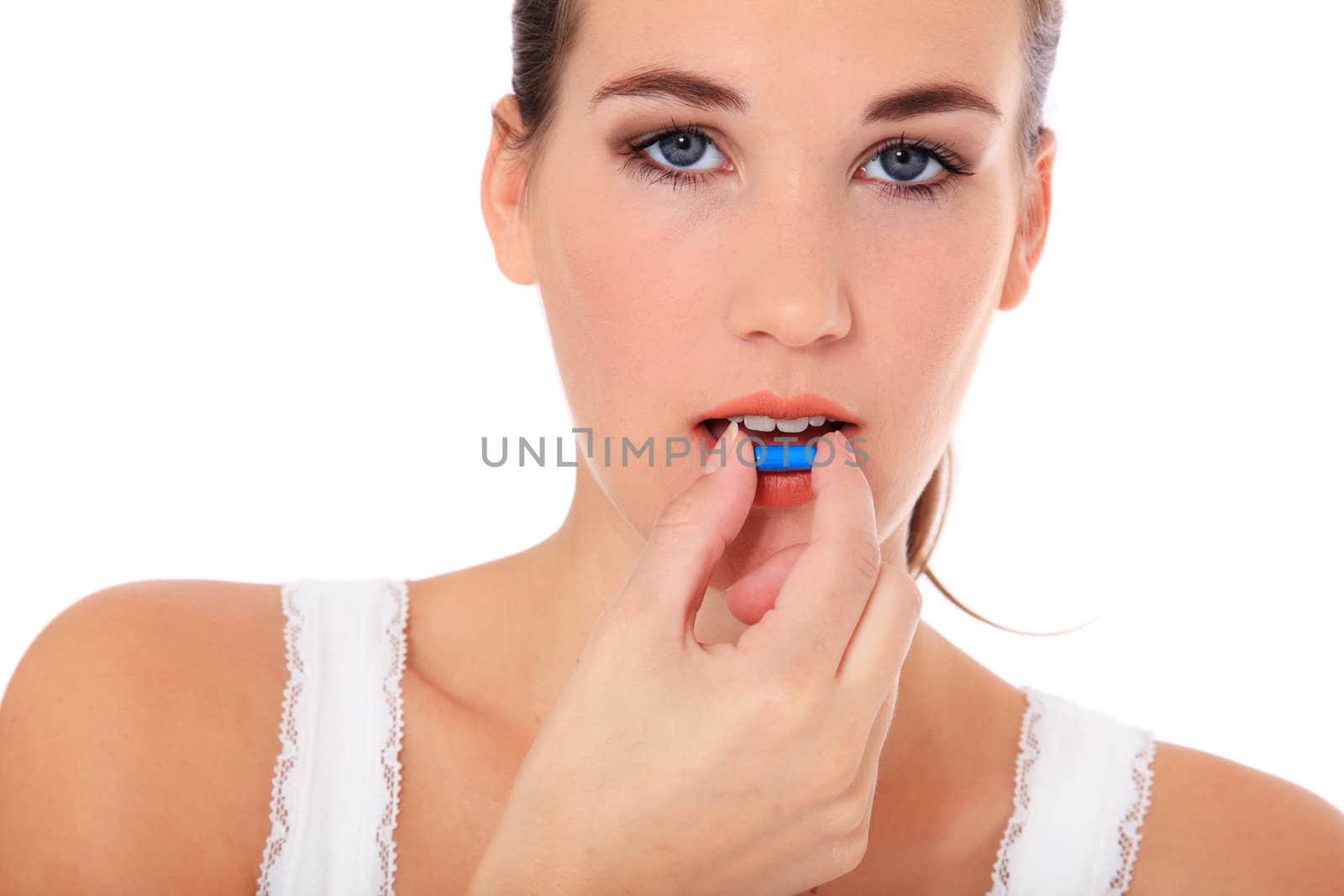 Attractive young woman taking a pill. All on white background.