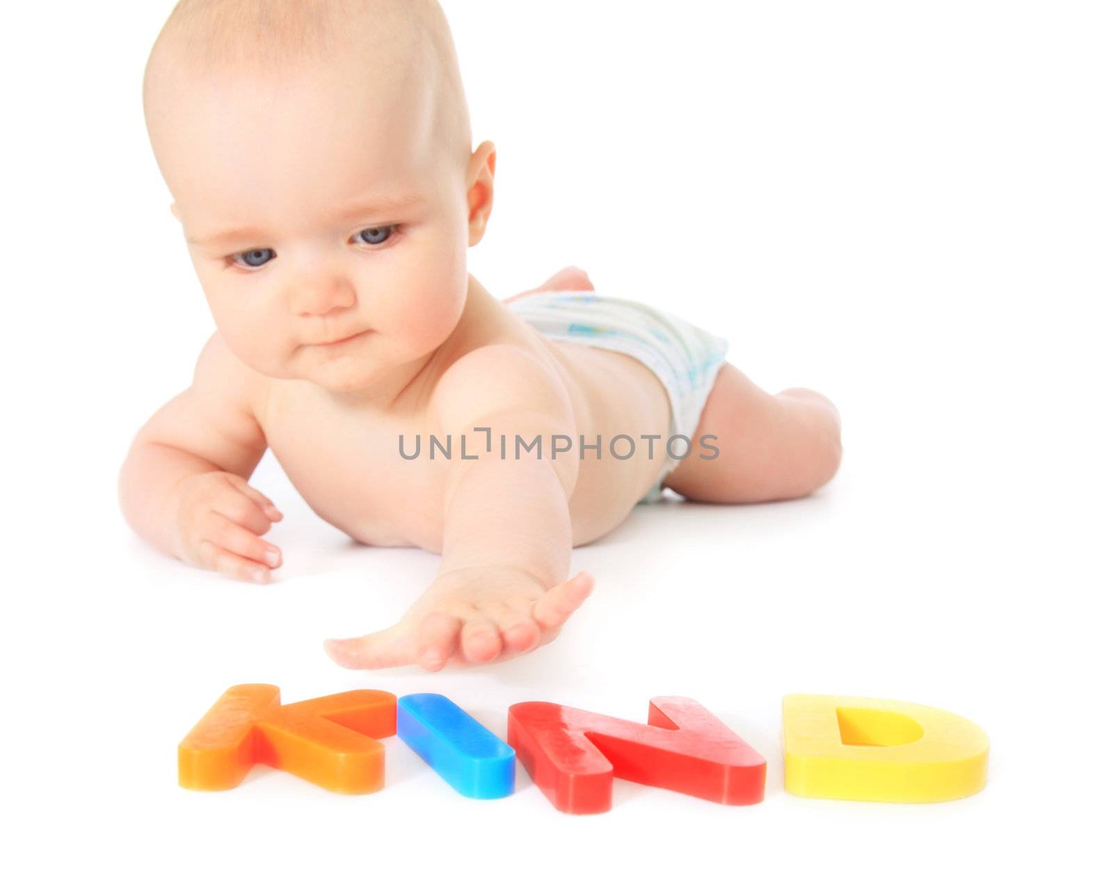 Newborn child focusing colorful letters building the term Kind (Engl.: child). All isolated on white background.