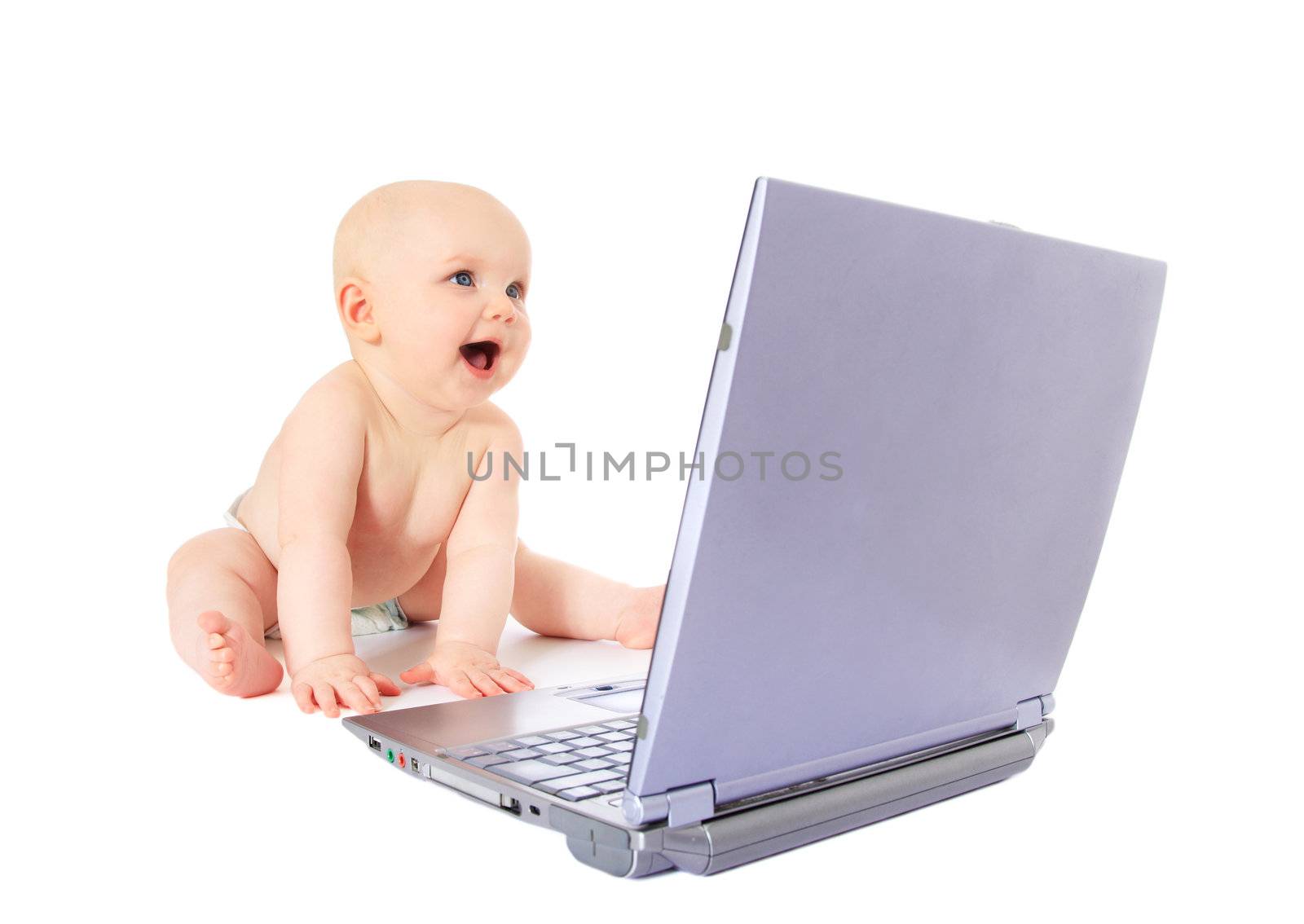 Newborn child playing with a notebook / laptop. All isolated on white background.