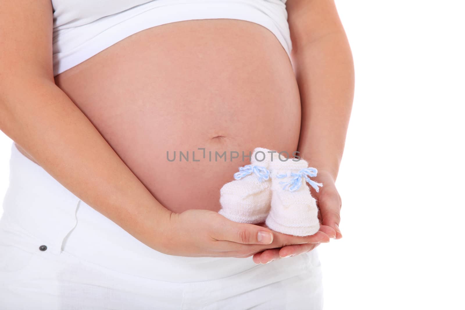 Pregnant woman holding baby shoes. All on white background.