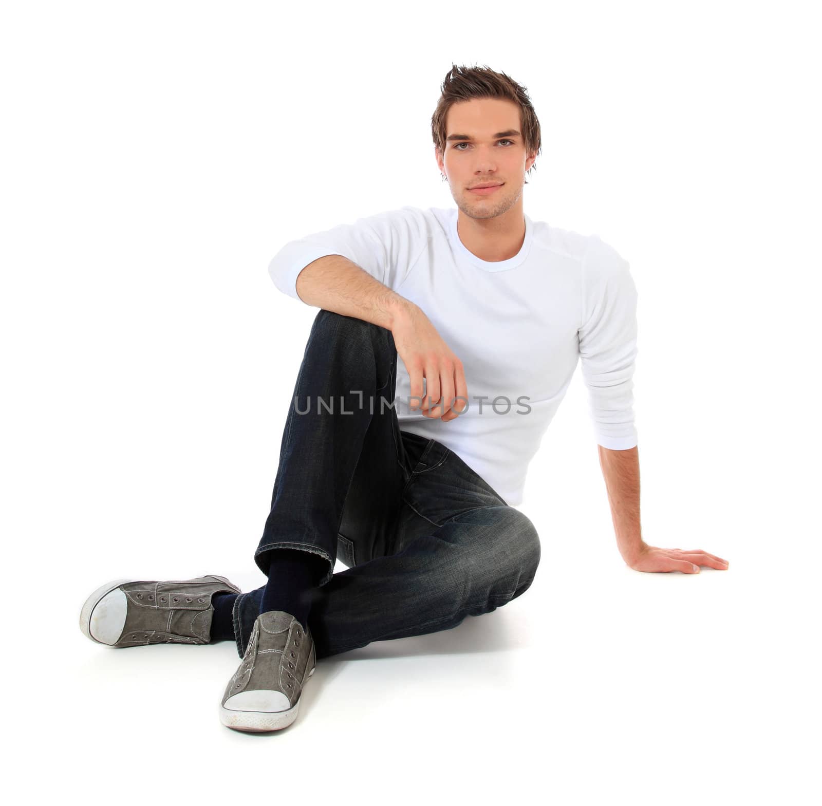 Attractive young man sitting. All on white background.