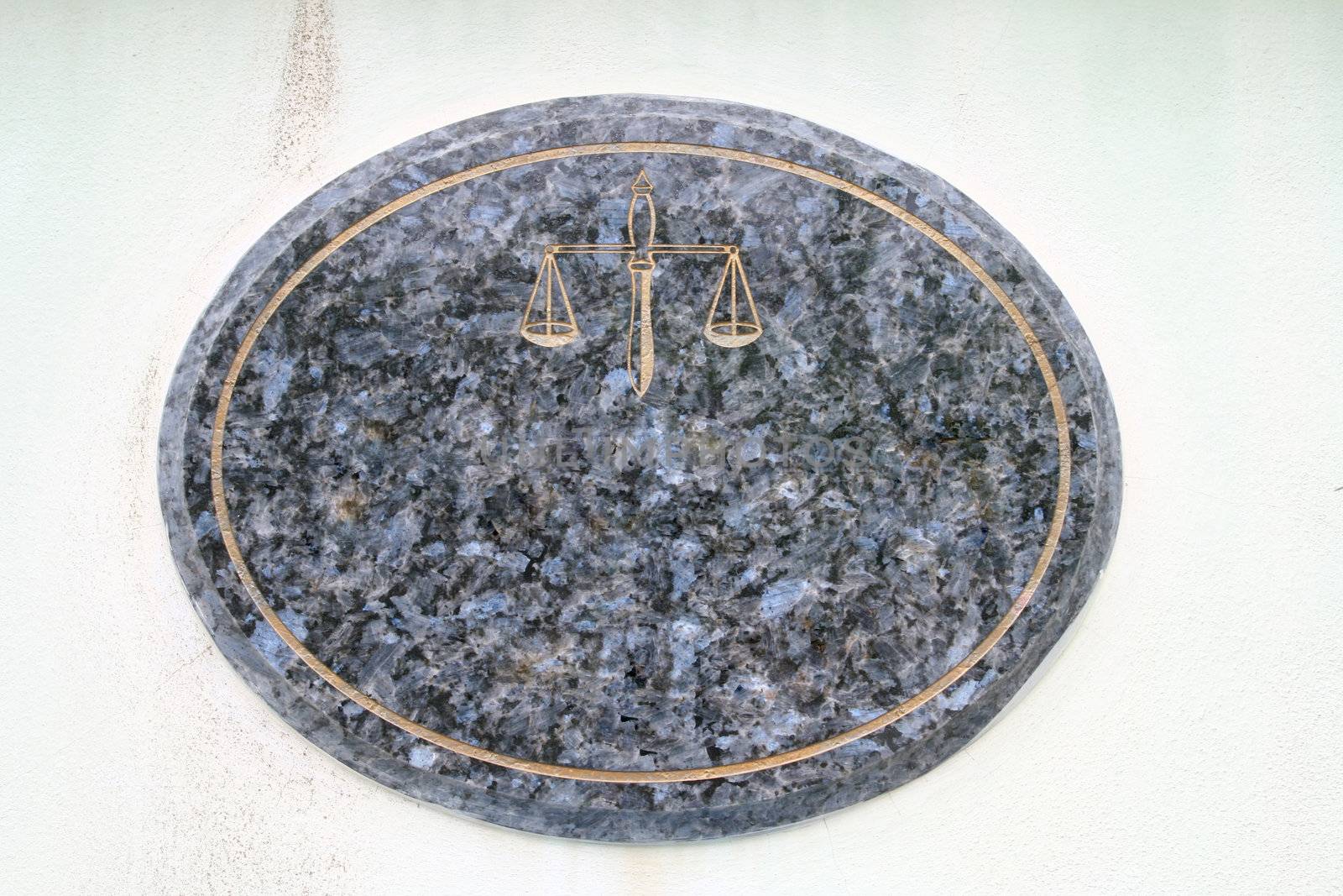 blank and Empty Mable Plate with Golden Scale of justice on White Wall at Street