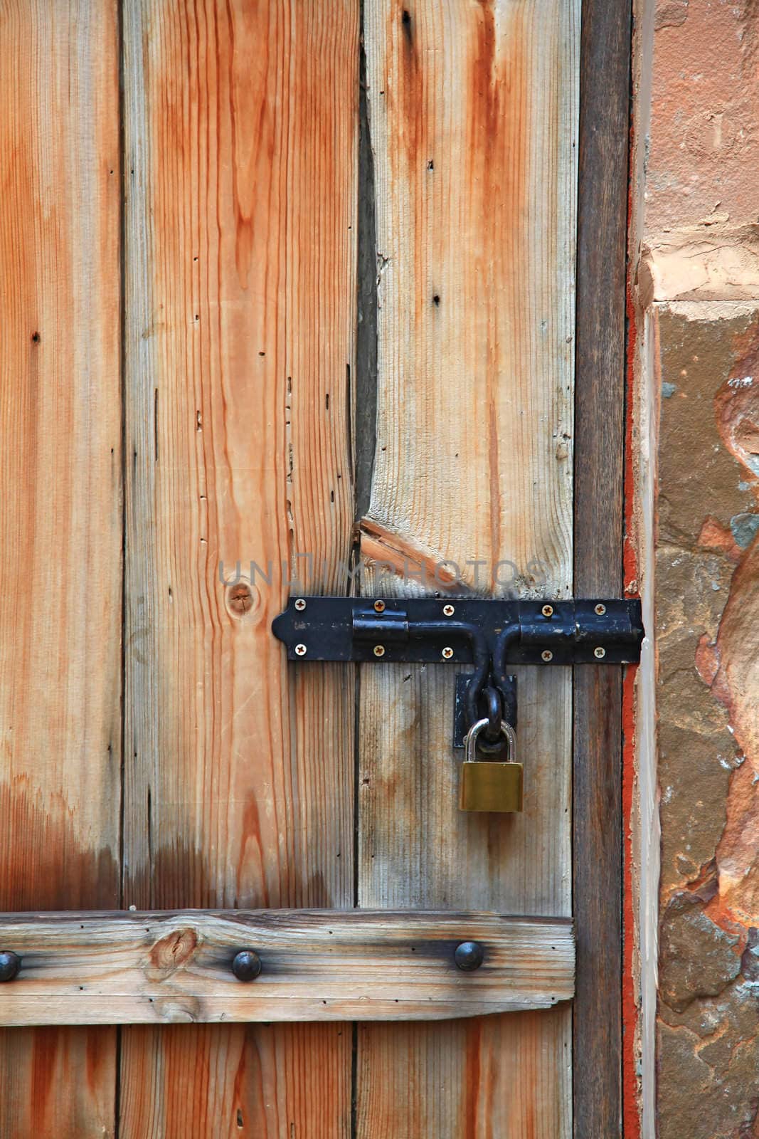 Old iron metal door handle locker on vintage italian style wooden door, vertical