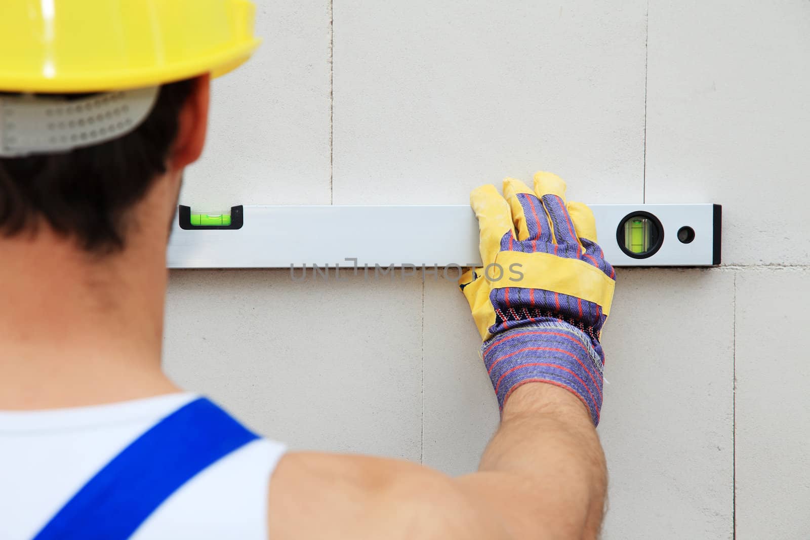 Construction worker using level.