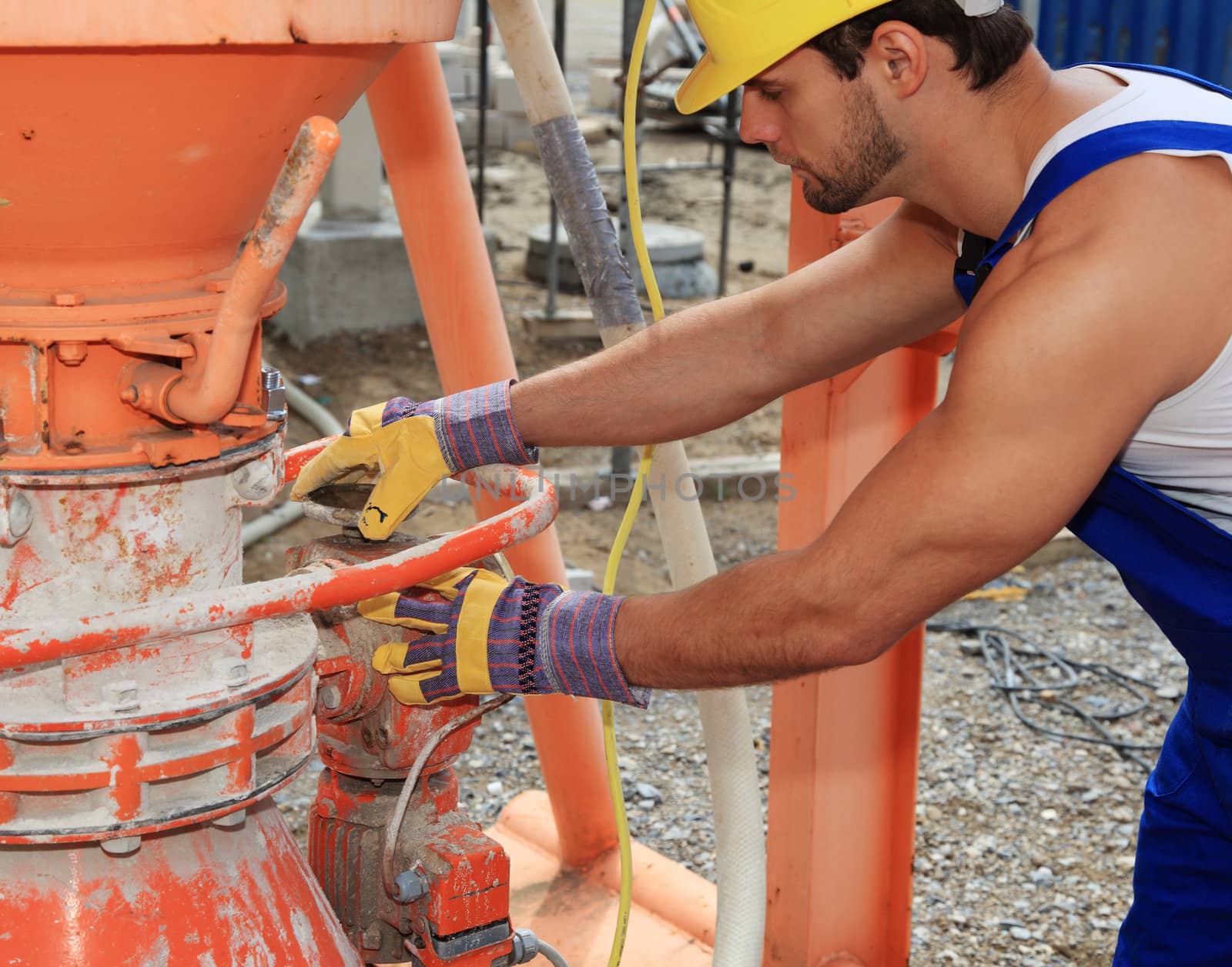 Construction worker at cement mixer.