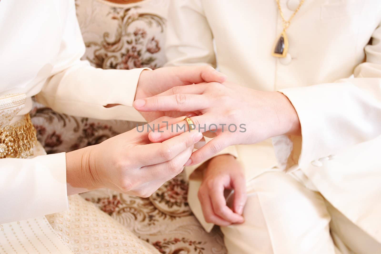 bride putting a wedding ring on groom 's finger