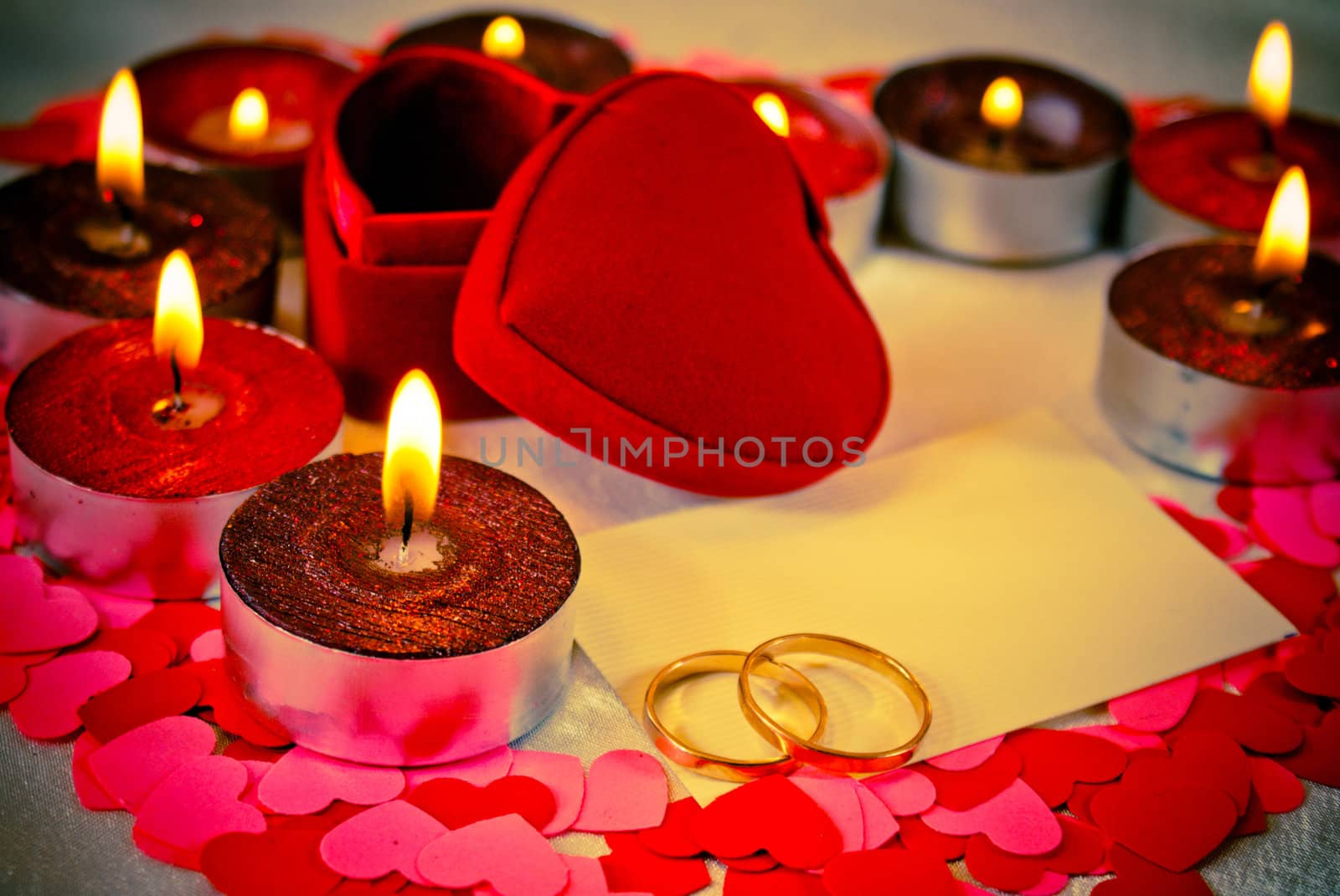 Blank card and two rings and candles. Shallow depth of field.