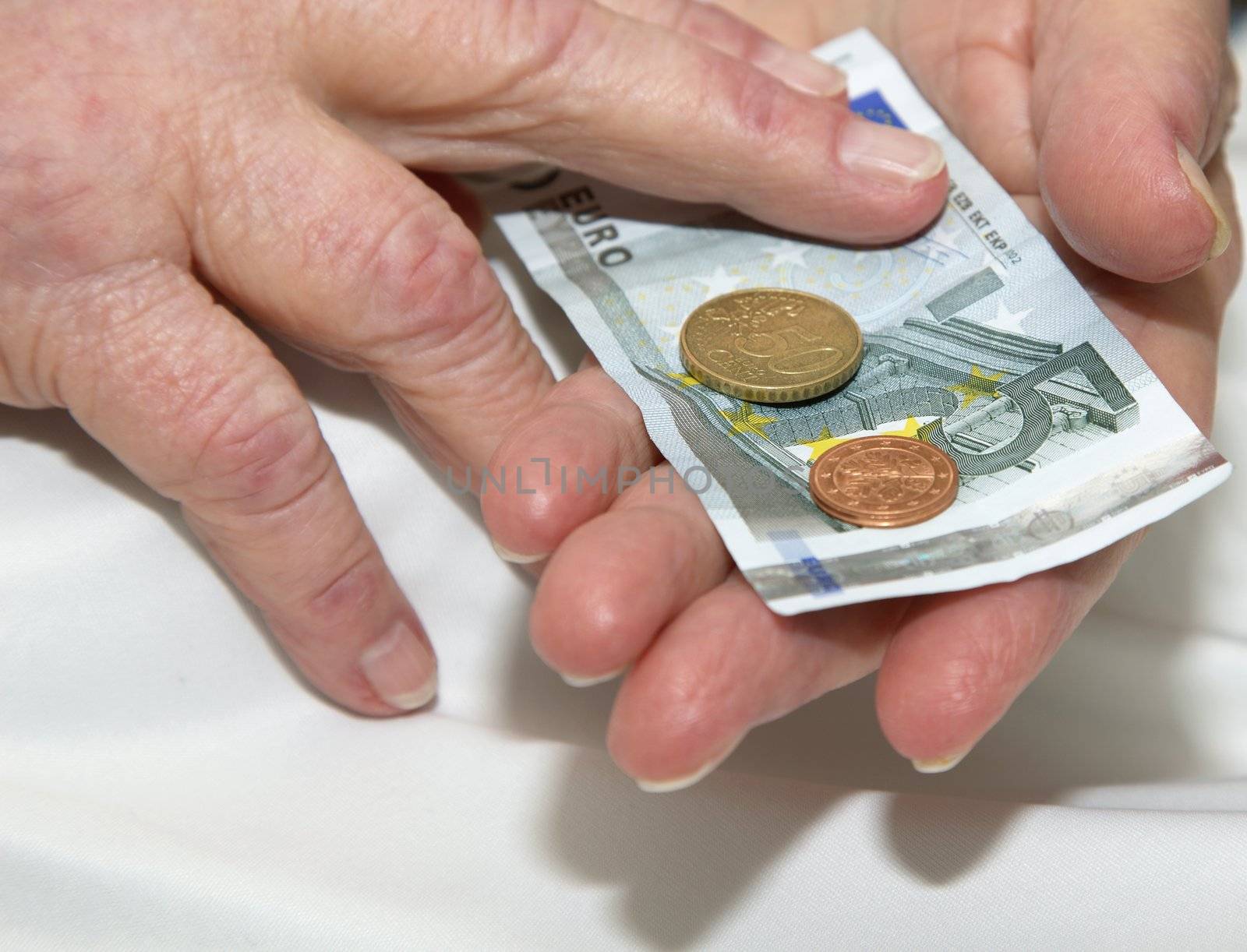 Old wrinkled hands of an elderly person, counting money.