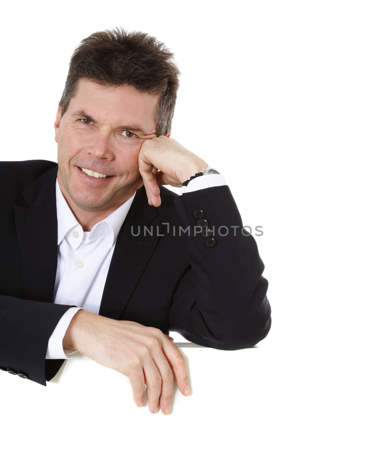 Attractive middle-aged man standing behind blank white wall. All on white background.