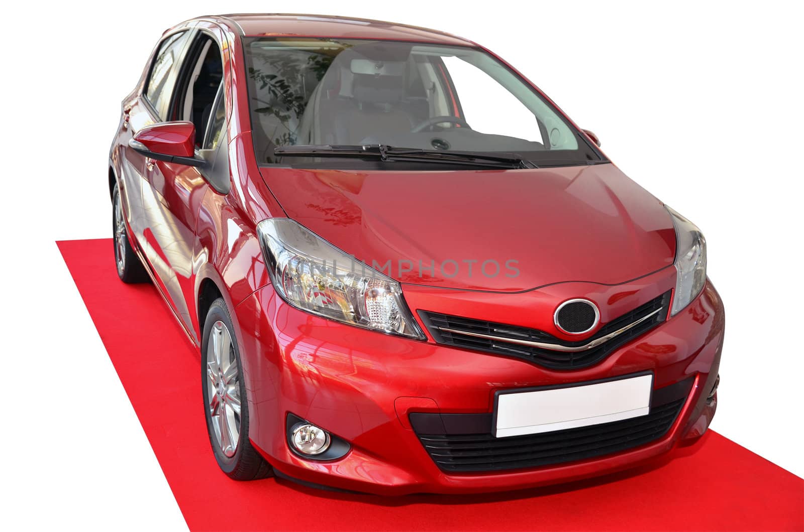 New Toyota Yaris on red carpet. Isolated on white.