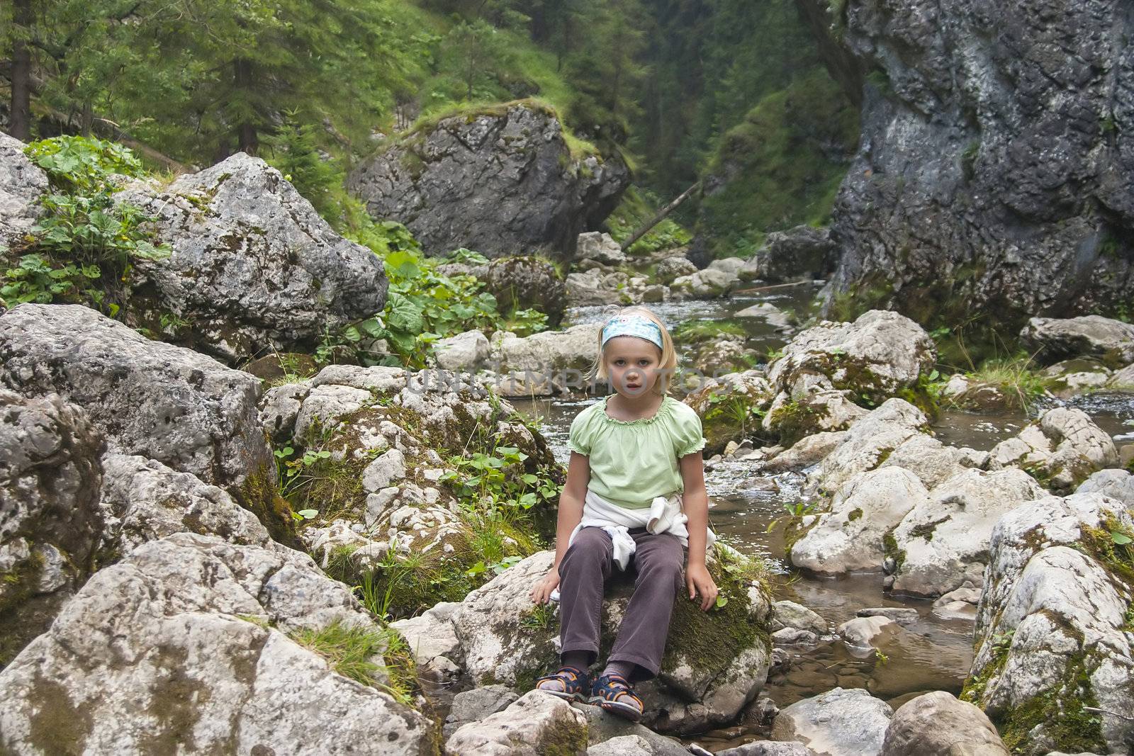 small tourist sitting by a mountain river, High Tatras, Slovakia