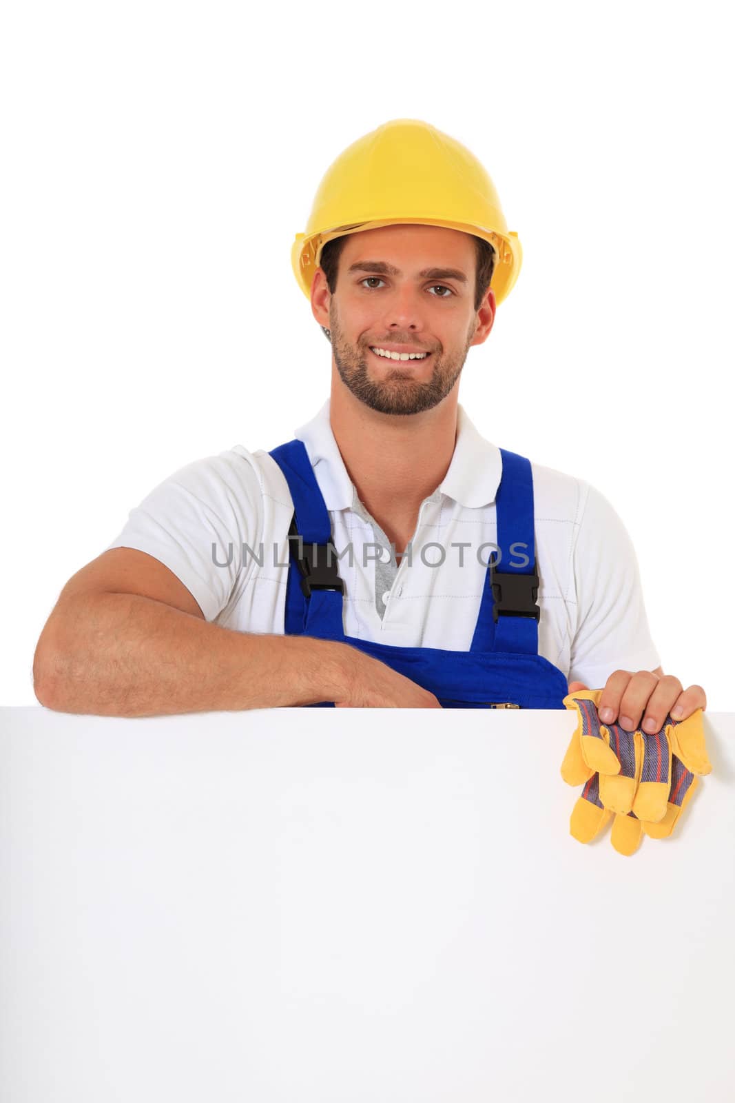 Construction worker standing behind white wall. All on white background.