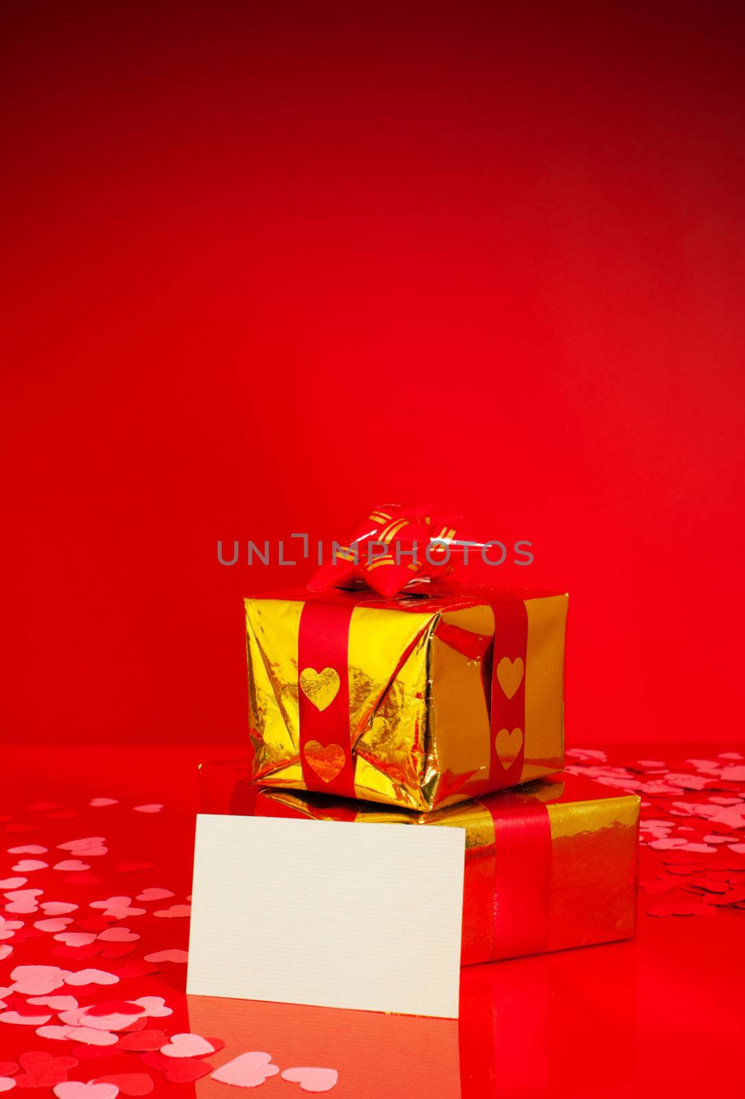 Two presents and blank card against red background
