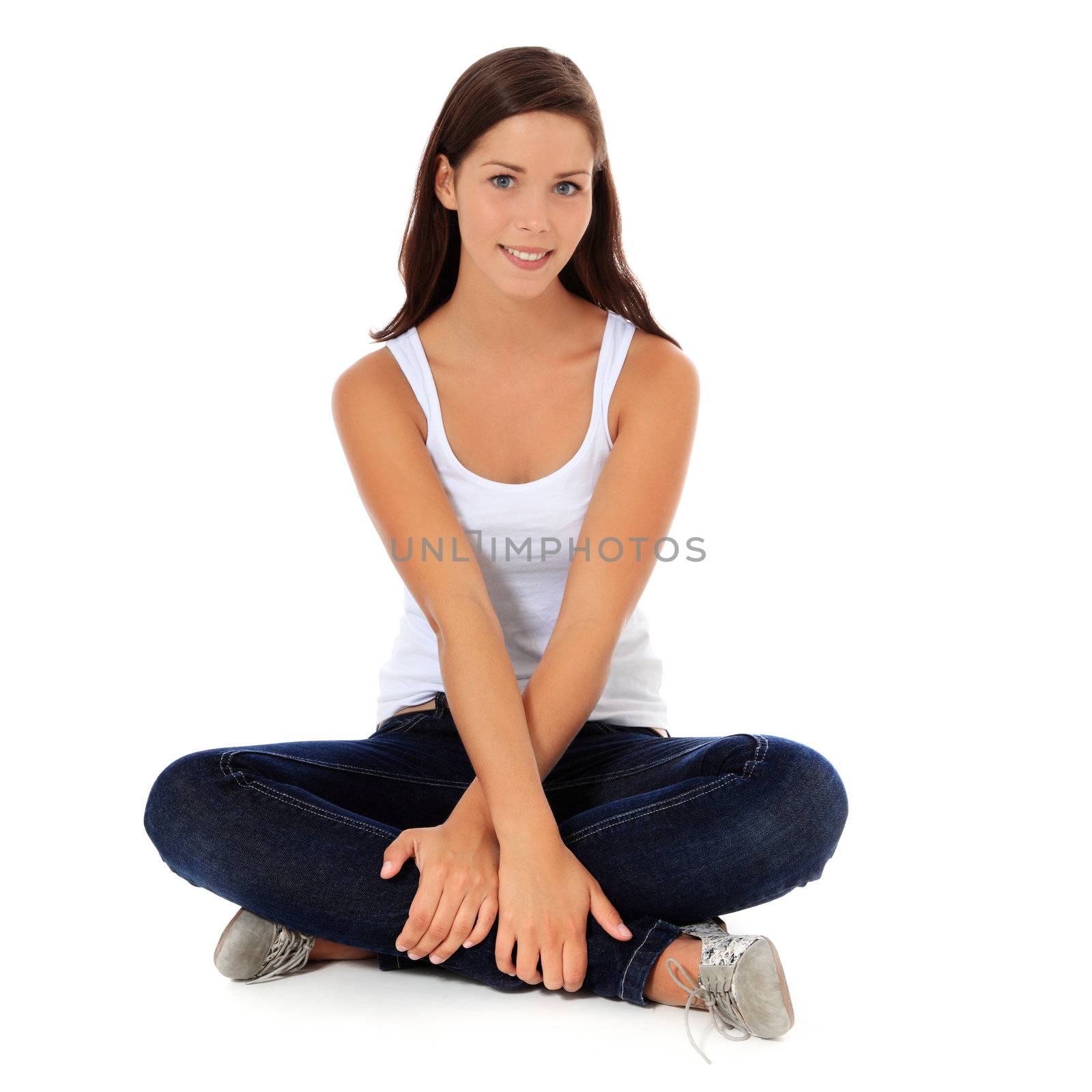 Attractive young woman sitting on the floor. All on white background.