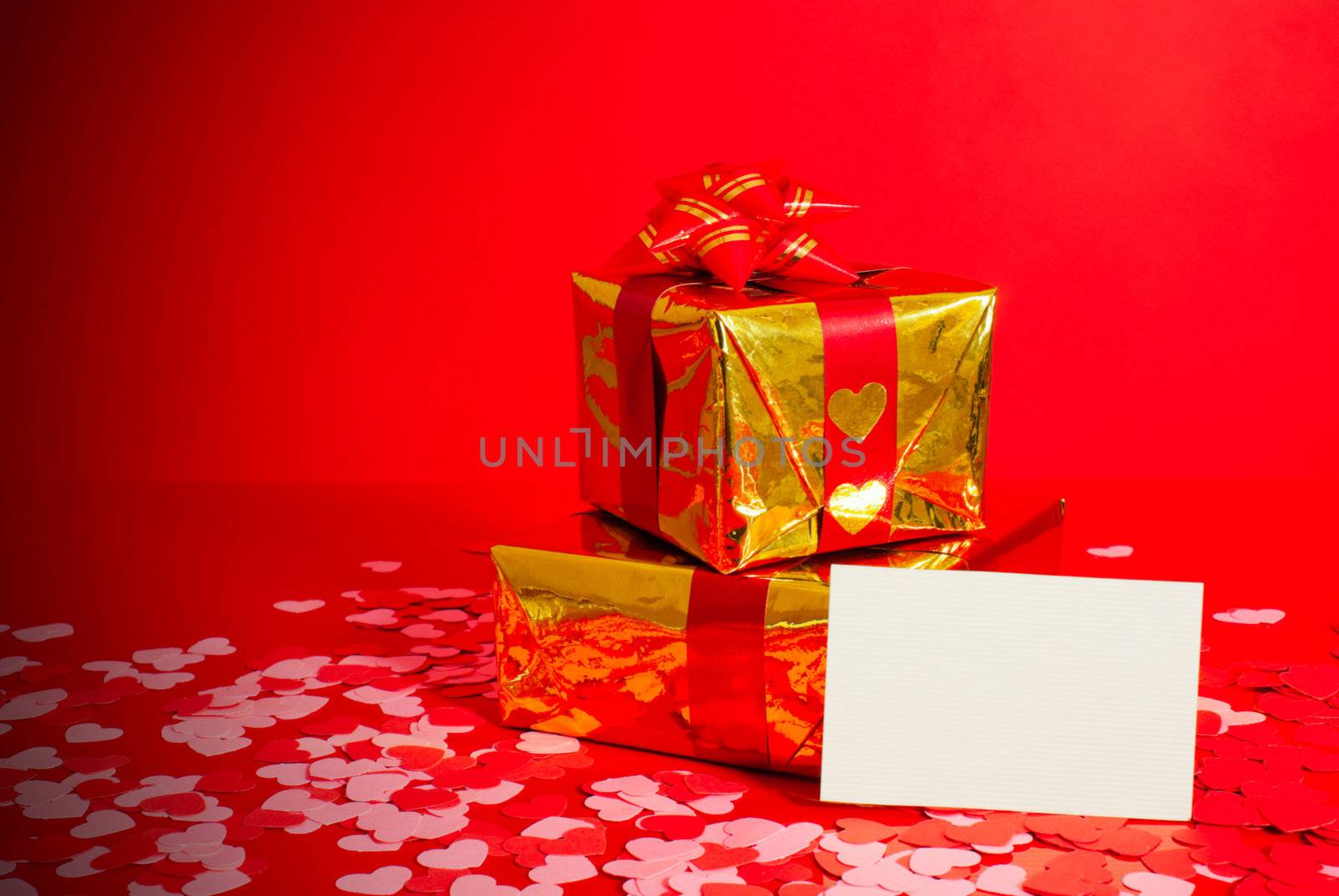 Two presents and blank card against red background