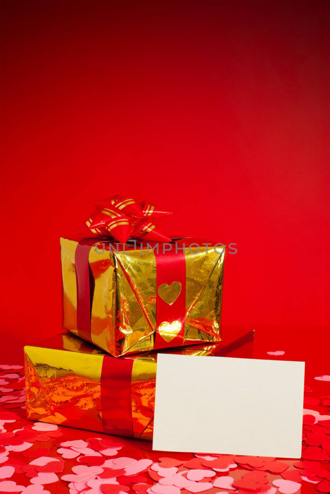 Two presents and blank card against red background