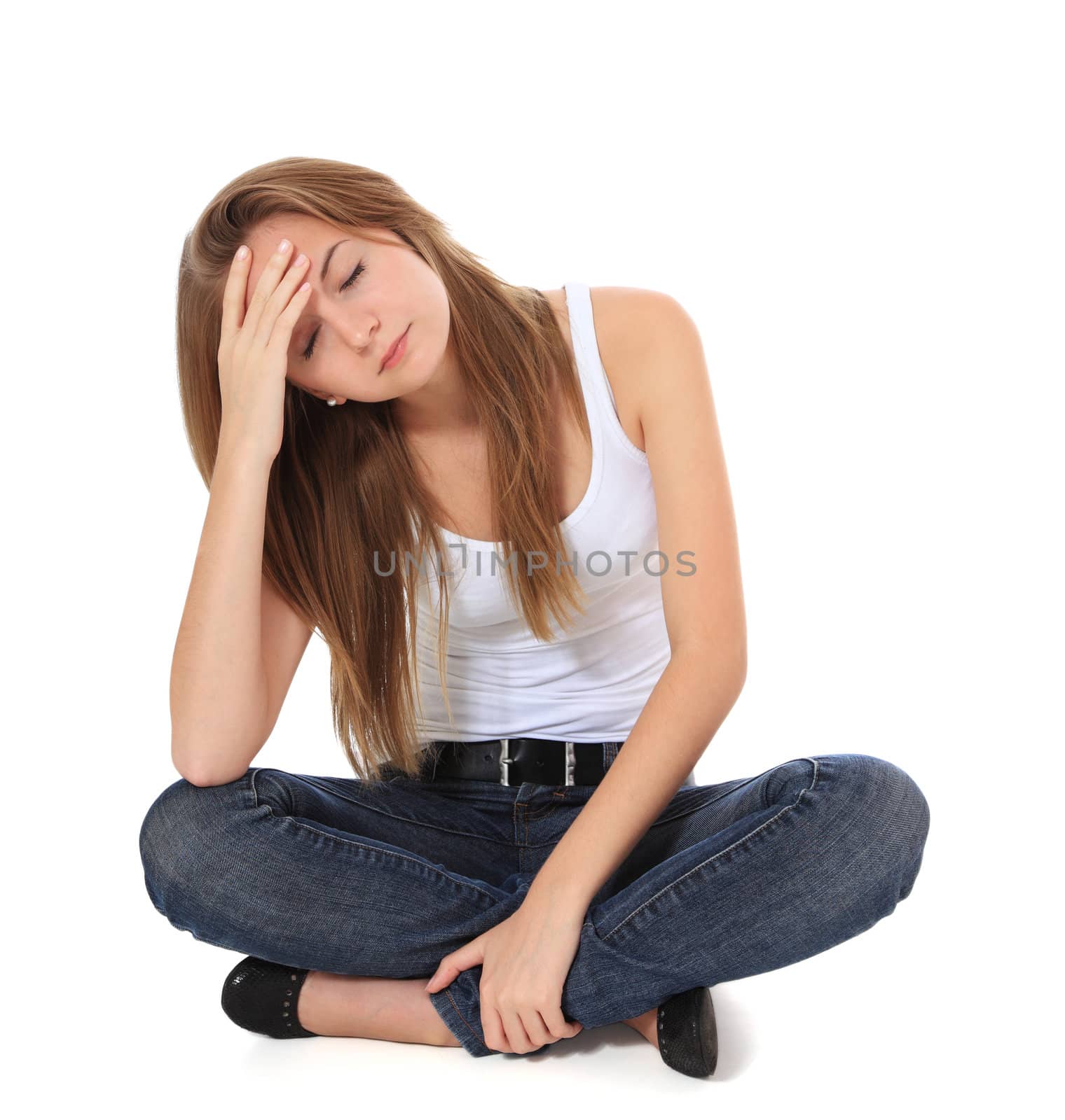Full length shot of a frustrated girl sitting on the floor. All on white background.