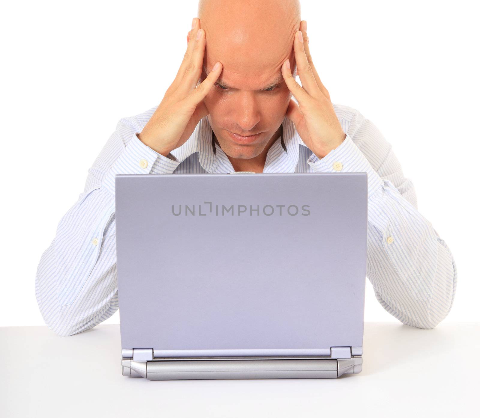 Frustrated man sitting in front of his laptop. All on white background.