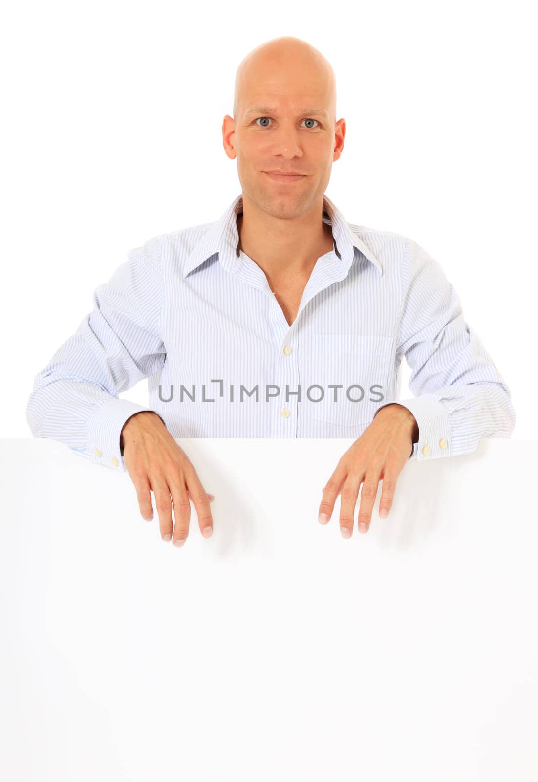 Attractive young man standing behind white wall. All on white background.