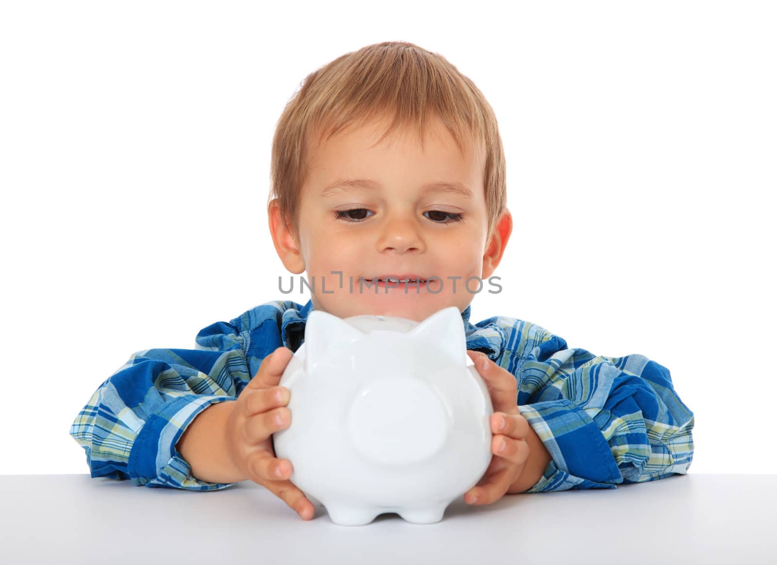Cute caucasian boy with his piggy bank. All on white background.