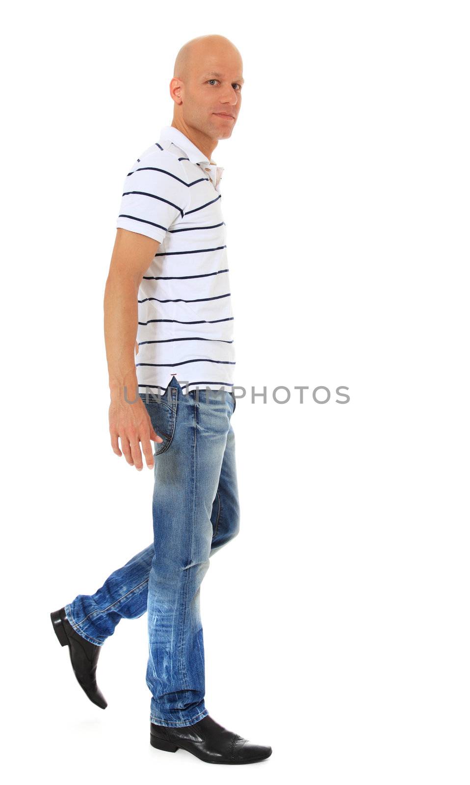 Full length shot of an attractive man walking. All on white background.