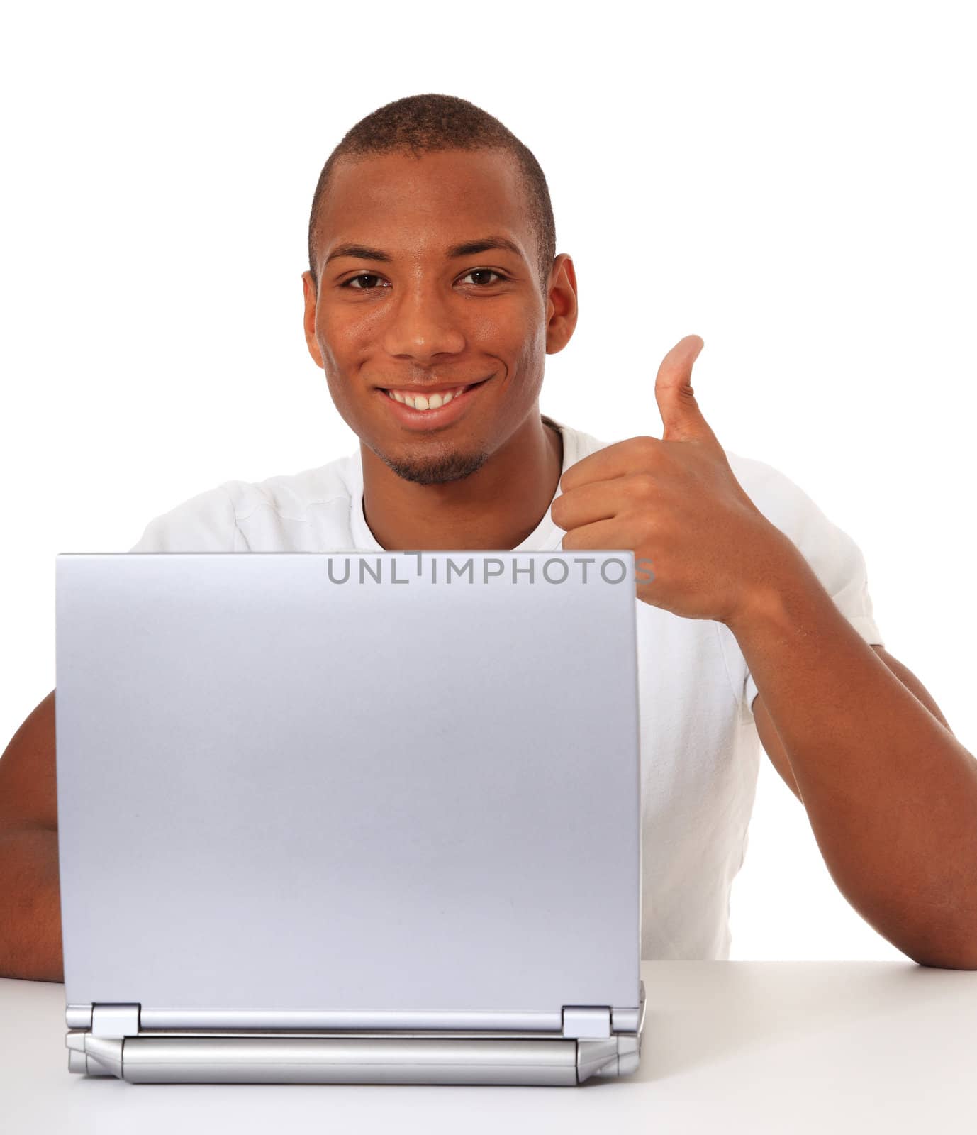 Attractive black guy showing thumbs up while using laptop. All on white background.