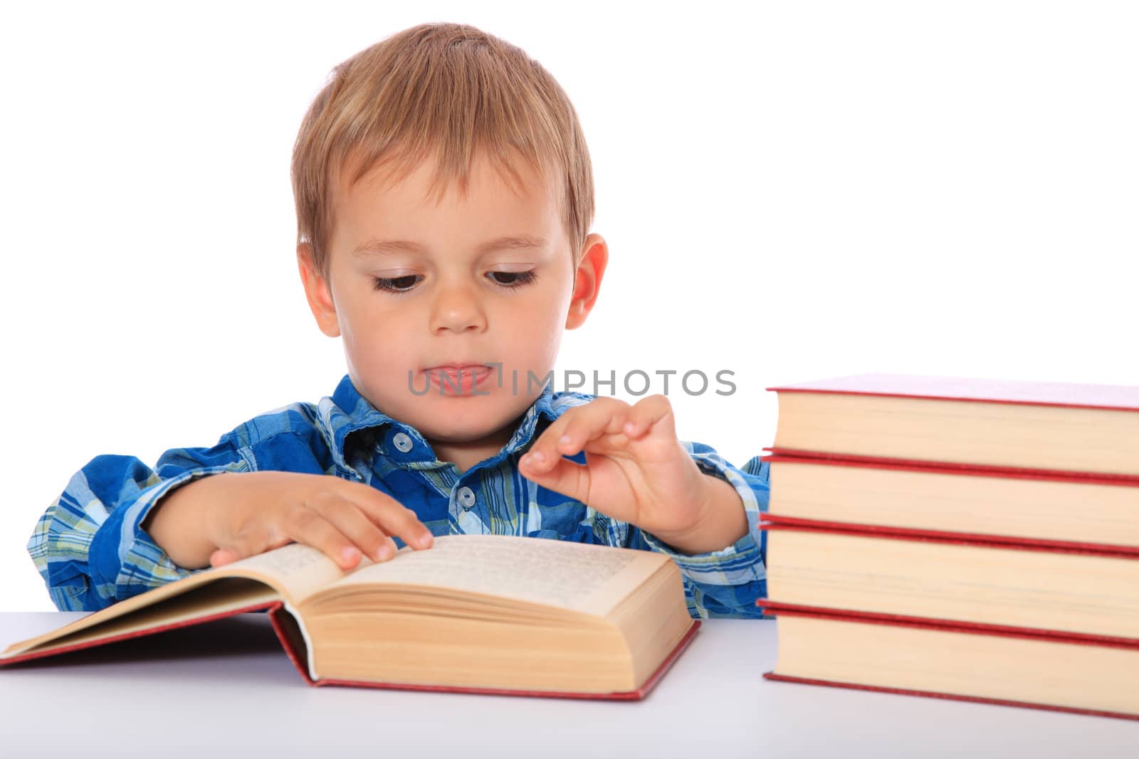 Cute caucasian boy looking through a book. All on white background.