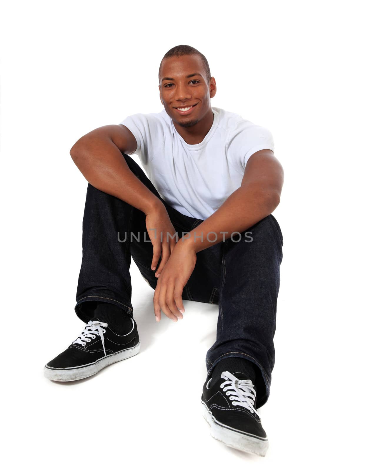 Attractive black man sitting on the floor. All on white background.
