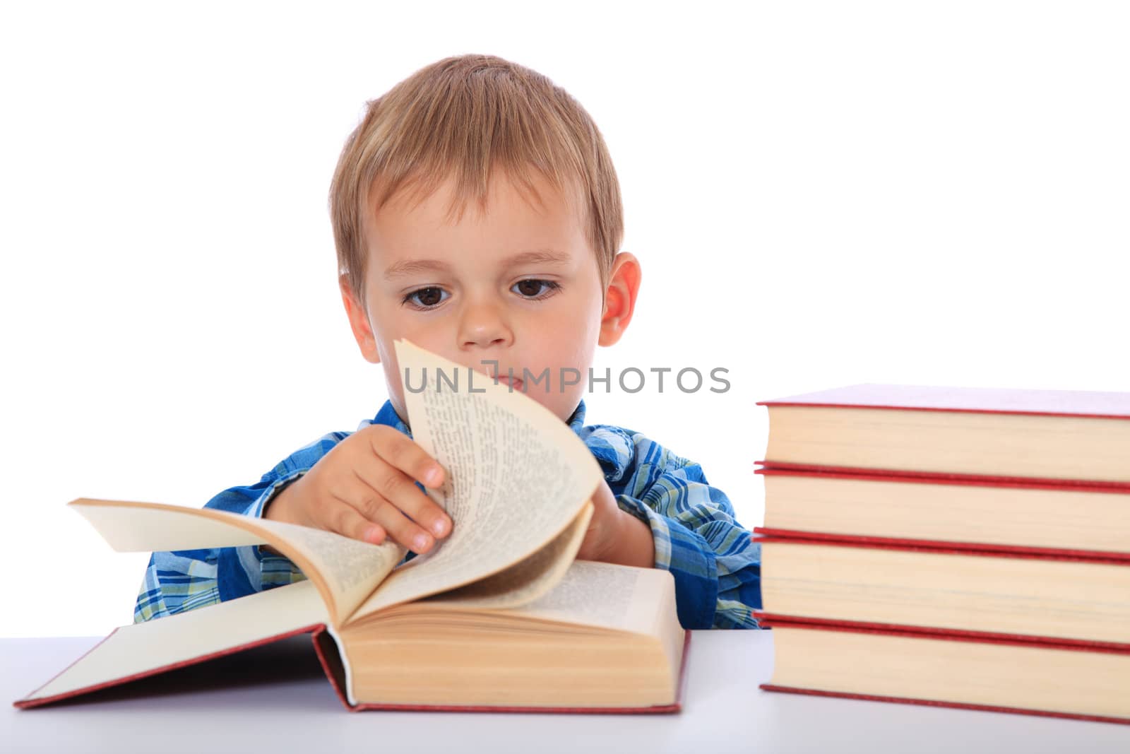 Cute caucasian boy looking through a book. All on white background.