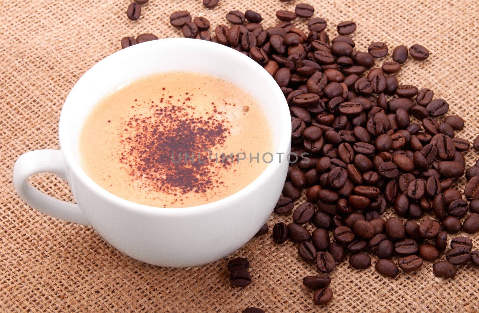 Coffee beans with cup on canvas