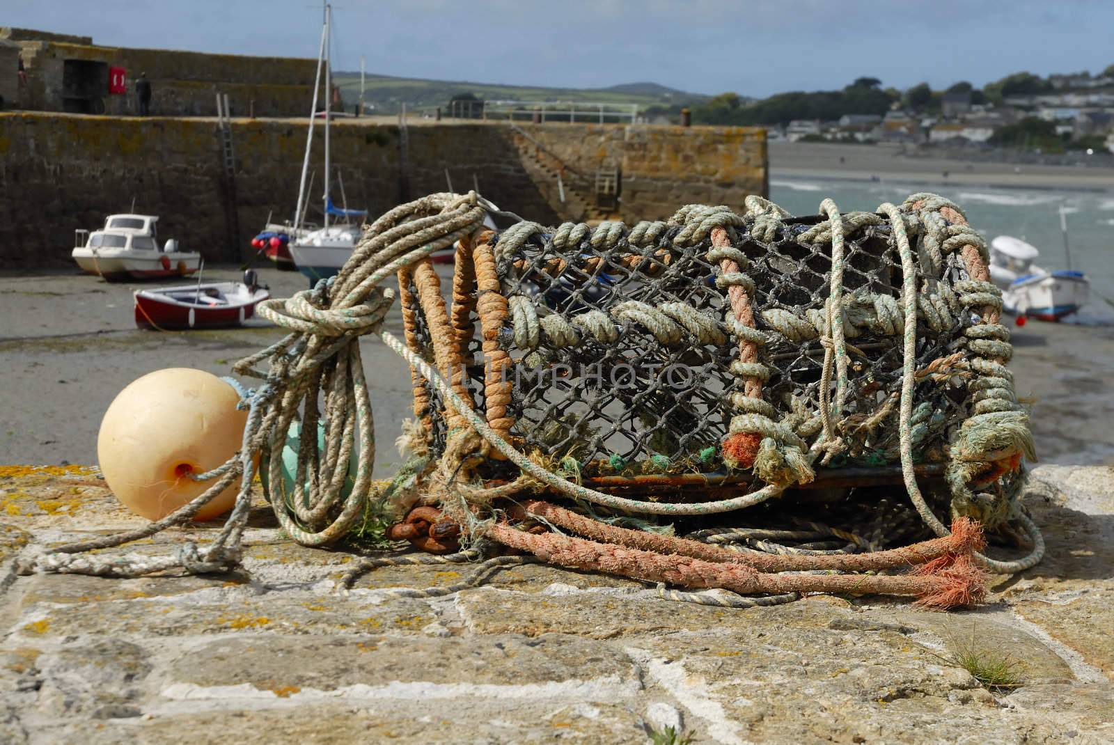 Lobster pot sat on a harbour wall in Cornwall, Uk.