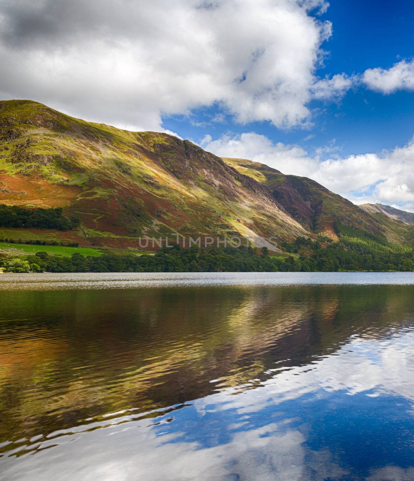 Mountains reflect into Buttermere calm lake in English Lake District