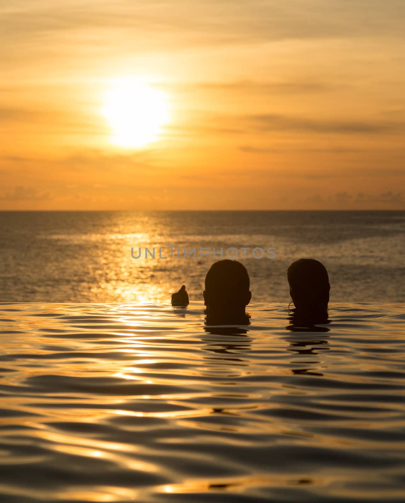 Edge of infinity swimming pool overlooking ocean at sunset
