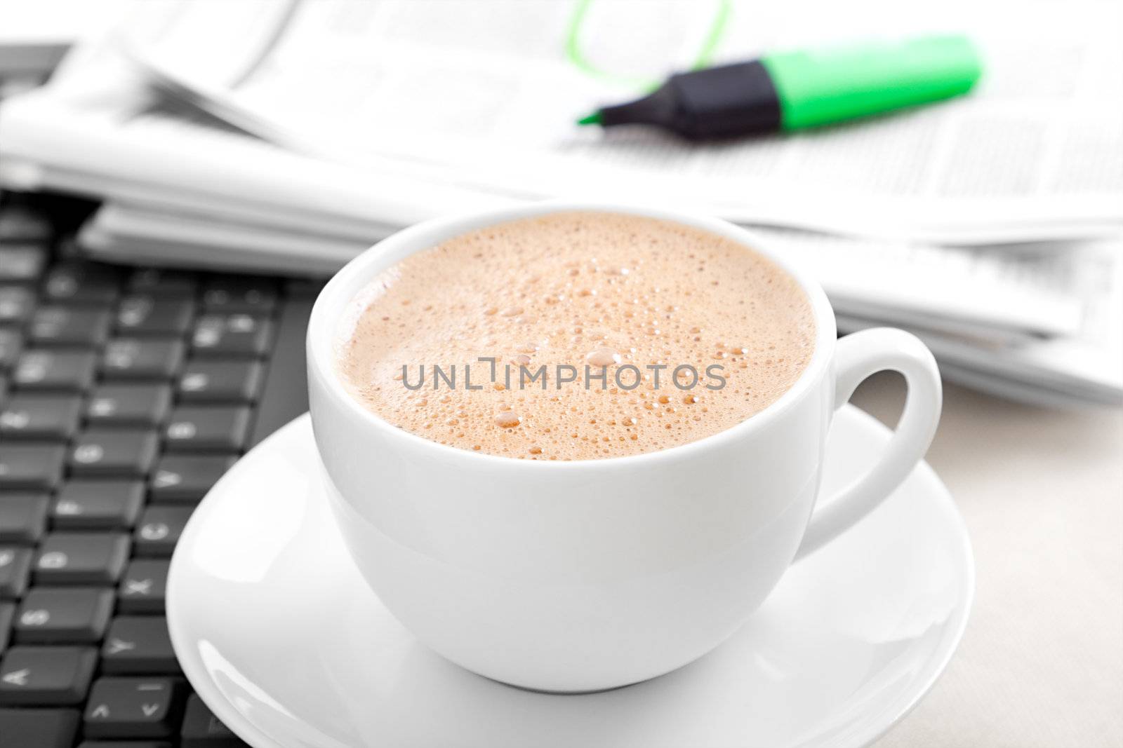 Cappuccino cup with laptop and newspaper 