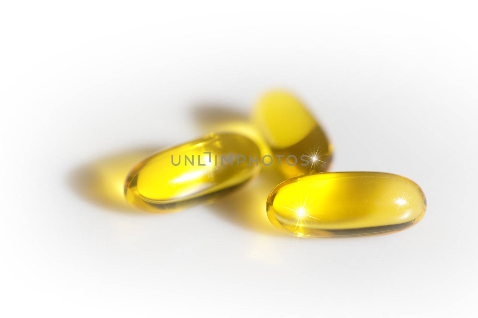 Pills or capsules in transparent yellow on white