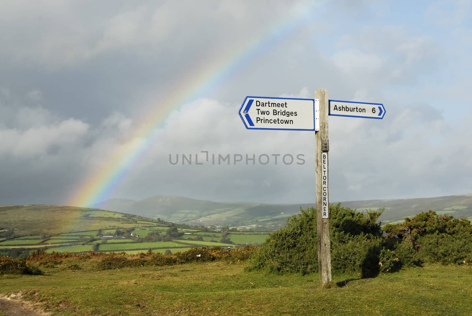 Rainbow over a signpost on dartmoor, Devon, UK.