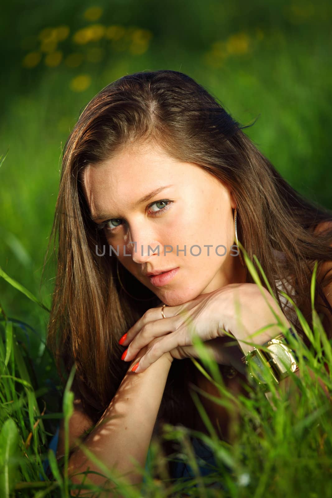 brunette lays on green grass