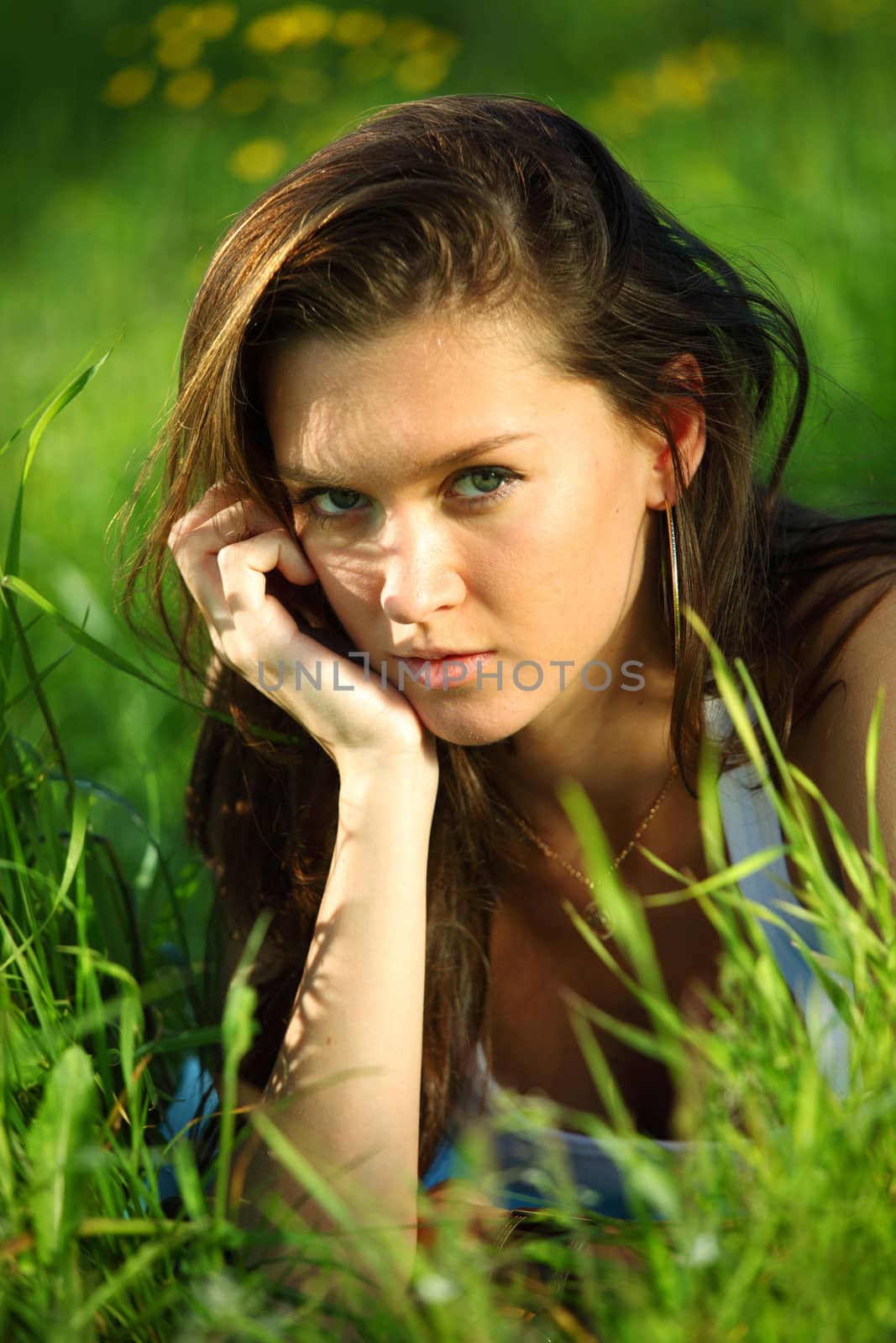 brunette lays on green grass