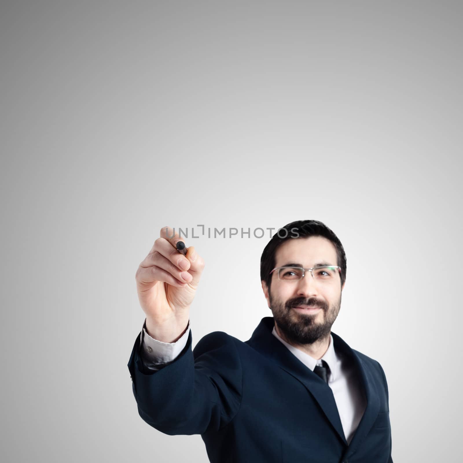 business man writing on imaginary screen on gray background