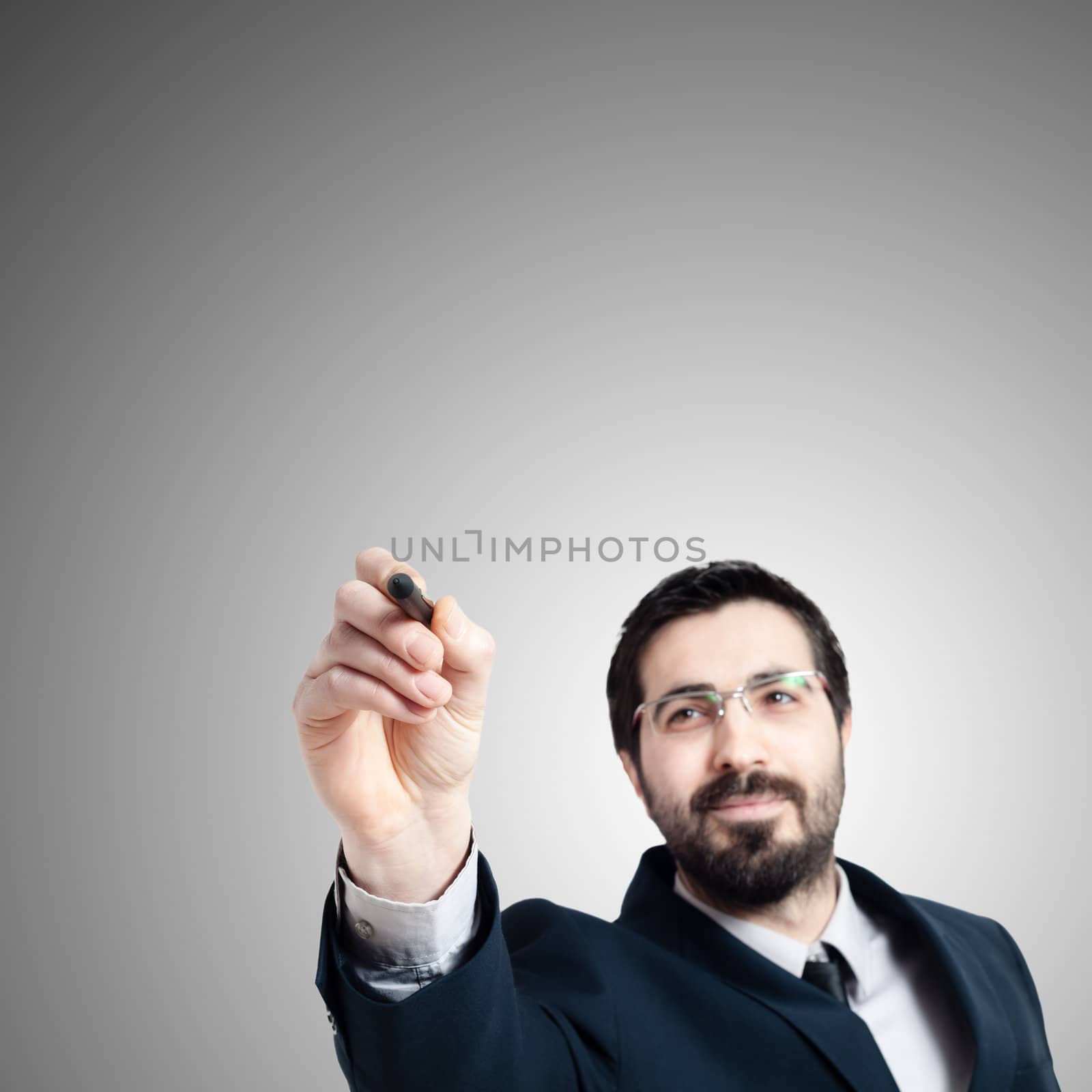 business man writing on imaginary screen on gray background
